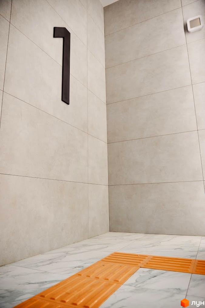 Фотографія поверху в Будівельному проєкті Оселя Парк. Зображення плитки на підлозі та стінах, а також номер поверху.