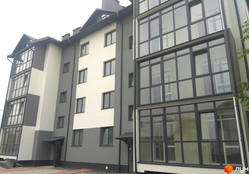 Фасад житлового комплексу на вулиці Глібова, 6, з великими панорамними вікнами та сірими і білими елементами. Перед будинком розташована прибудинкова територія.