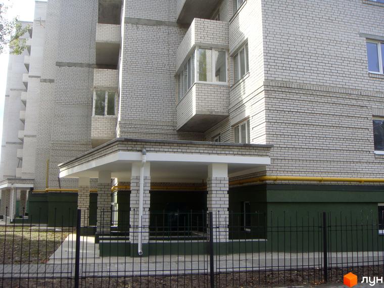 Зовнішній вигляд будинку житлового комплексу Світлиця з білою цегляною облицюванням та прибудинковою територією.