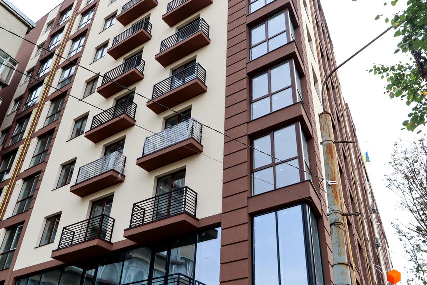 Фасад житлового комплексу Central House з балконами та великими вікнами. Зовнішній вигляд новобудови з коричневими та бежевими елементами.