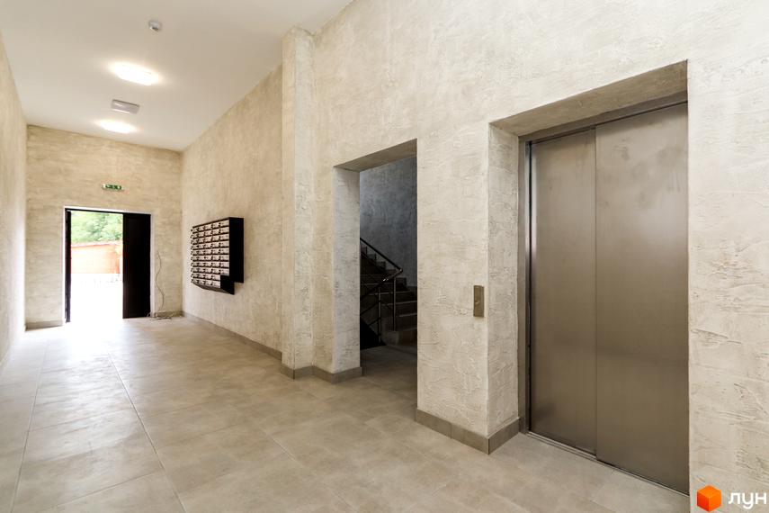 Сучасний хол житлового комплексу Central House з поштовими скриньками та ліфтом. Відкритий вхід до під'їзду з видом на зелень.