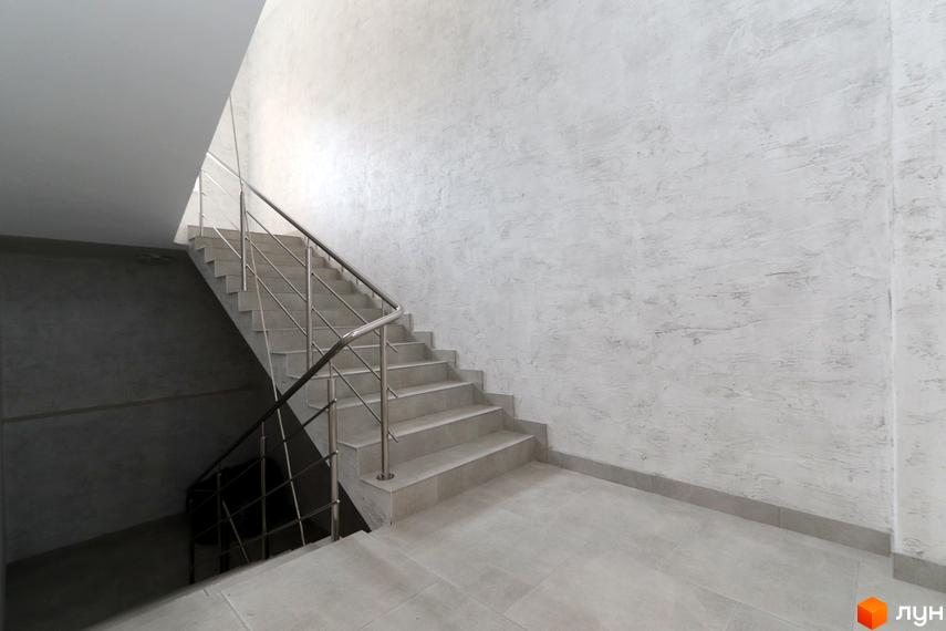Сходи в ЖК Central House з металевим поручнем та світлими стінами. Фотографія внутрішнього простору новобудови.