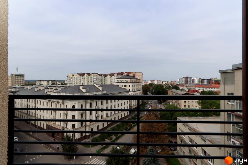 Вид на житловий комплекс Central House з балкона. Будівля має багатоповерхову забудову з типовими фасадами та дахами.