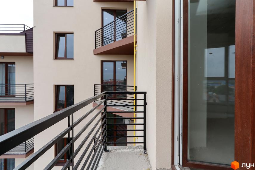 Зовнішній вигляд ЖК Central House з балконами та вікнами. Фасад будівлі світло-бежевого кольору з коричневими елементами.