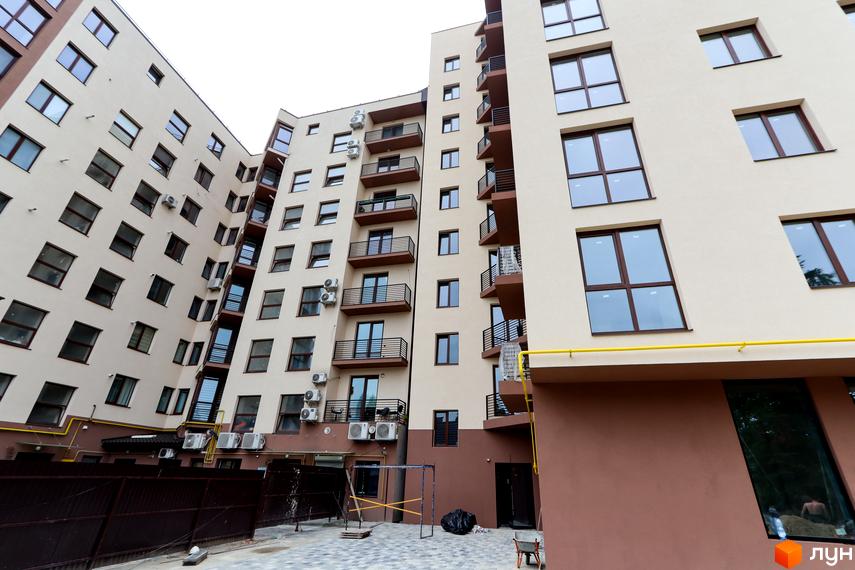 Зовнішній вигляд житлового комплексу Central House з численними вікнами та балконами. На прибудинковій території видно паркан та елементи благоустрою.