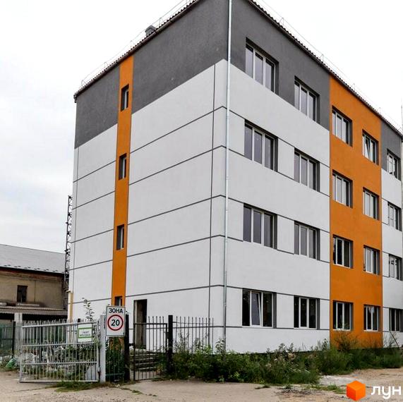 Зовнішній вигляд новобудови ЖК Smart House з біло-сірими фасадами та помаранчевими акцентами. На прибудинковій території видно огорожу та зелені насадження.