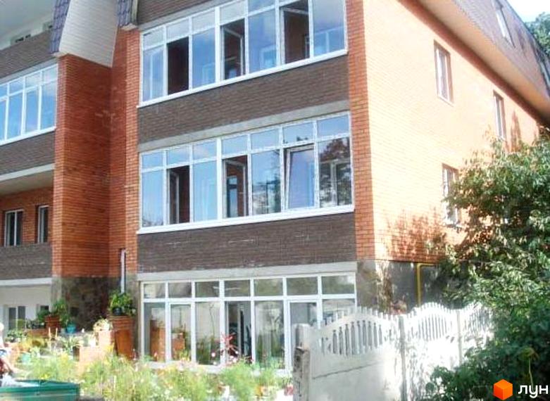 Зовнішній вигляд житлового комплексу на вул. Київська, 45в з великими вікнами та прибудинковою територією з рослинністю.