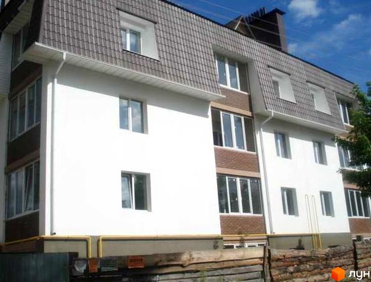 Зовнішній вигляд будинку на вул. Вериківського, 23. Прибудинкова територія з зеленими насадженнями та огорожею.