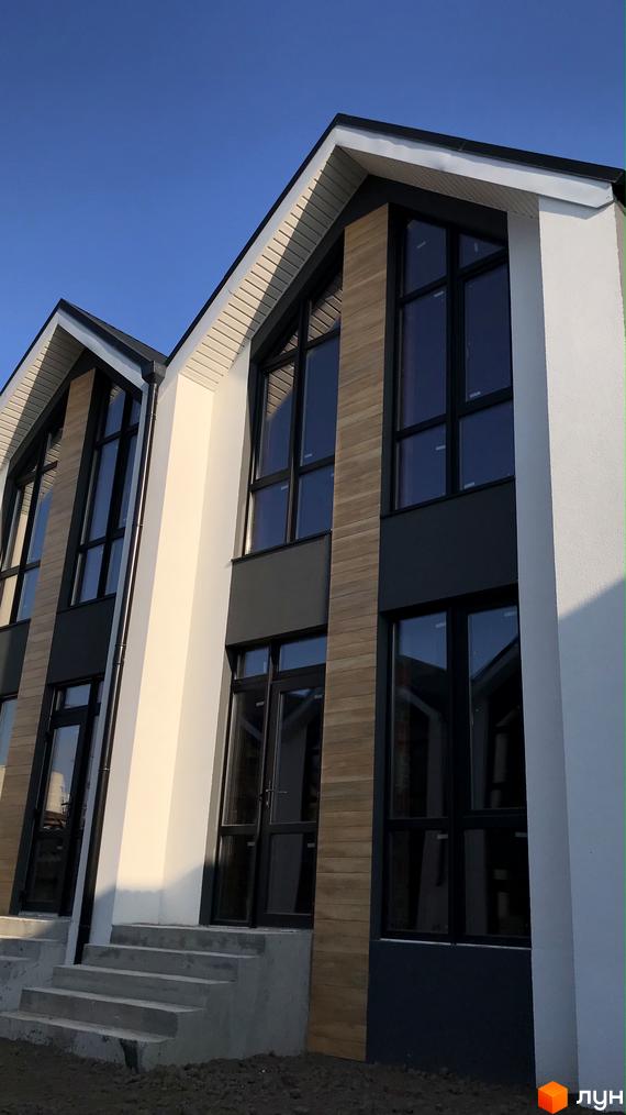 Зовнішній вигляд таунхаусів Well Home з великими вікнами та оздобленням під дерево. Вигляд на сходи до входу в будинок.