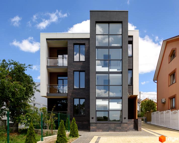 Зовнішній вигляд будинку в Житловому комплексі Elite House з великими вікнами та балконами. Навколо зелені насадження та доглянута територія.