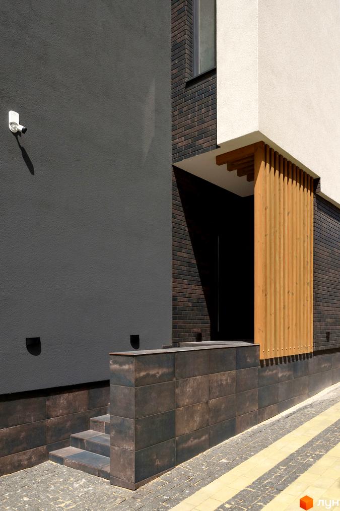 Фасад будинку з оздобленням з цегли та дерев'яними елементами. Вхідна група з сходами та облицюванням плиткою в Житловому комплексі Elite House.