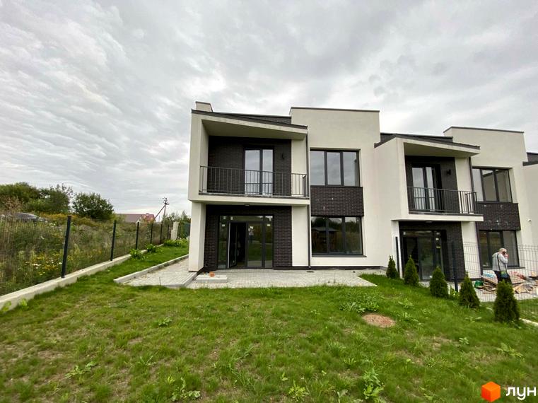 Таунхауси Rubicon Cottages з білою та темно-коричневою обробкою, балконами та великими вікнами, розташовані на зеленій ділянці з доріжками та парканом.