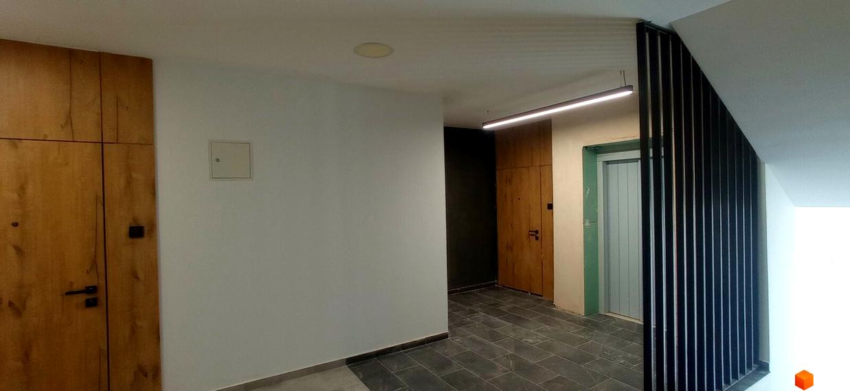 Сучасний дизайн холу ЖК Rubicon Premium з дерев'яними елементами та ліфтом. Зручний простір для мешканців новобудови.