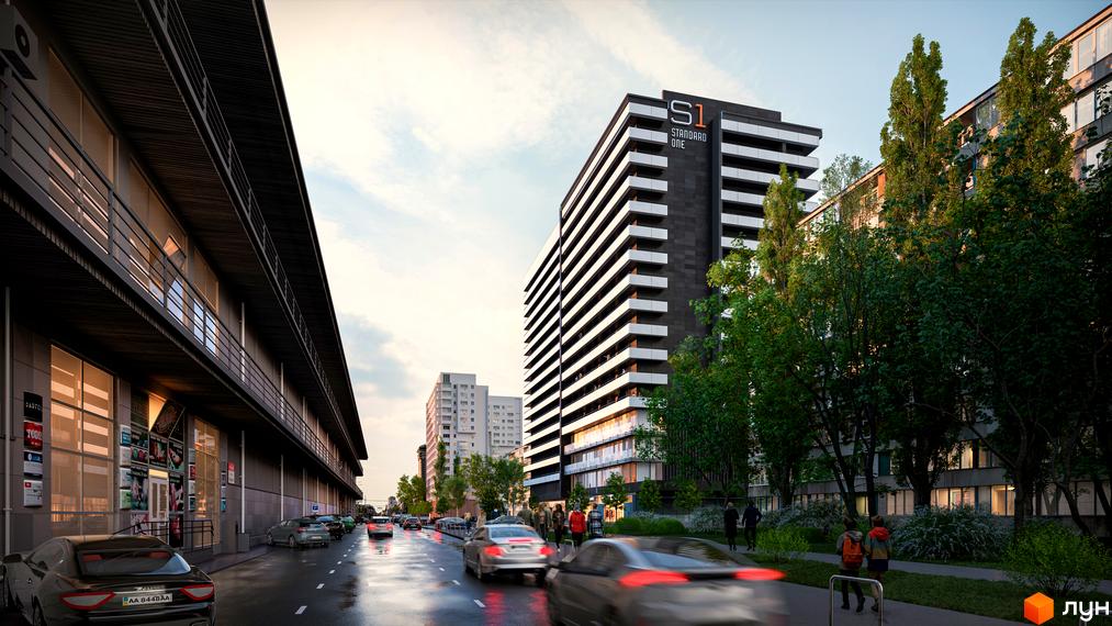 Зображення фасаду ЖК Standard One Obolon. Багатоповерховий будинок з балконами та великими вікнами, поруч зелені дерева та дорога з автомобілями.