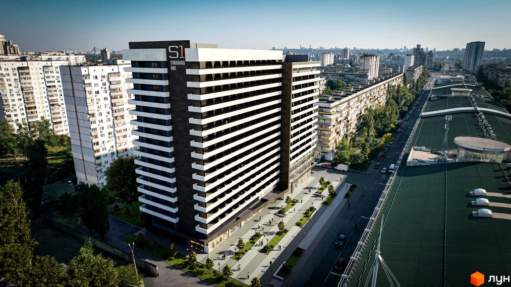 Зображення фасаду та прибудинкової території Новобудови Standard One Obolon. Висотна будівля з великими вікнами та озелененням навколо.