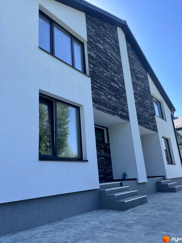 Дуплекси „На Драгоманова“ – це новобудова з білою та сірою цегляною обробкою фасаду, великими вікнами та вимощеною сірою плиткою прибудинковою територією.