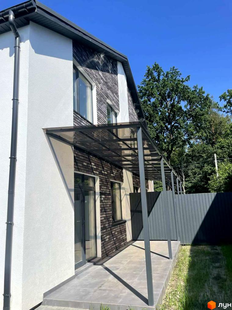 Новобудова Дуплекси „На Драгоманова“ з білою штукатуркою та темною цегляною облицовкою, навісом над терасою та огородженою територією.