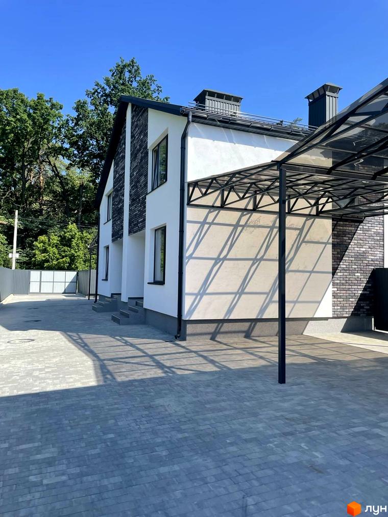 Дуплекси „На Драгоманова“: двоповерхові будинки з білою штукатуркою та темною цеглою, прибудинкова територія з бруківки та навісом для авто.