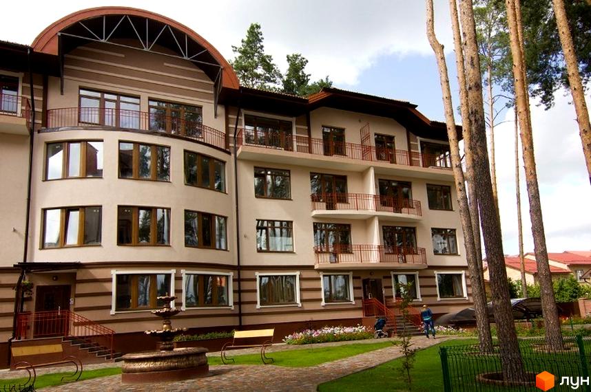 Зовнішній вигляд житлового комплексу ЖК Жемчужина з великими вікнами та балконами. Прибудинкова територія з фонтаном та зеленими насадженнями.