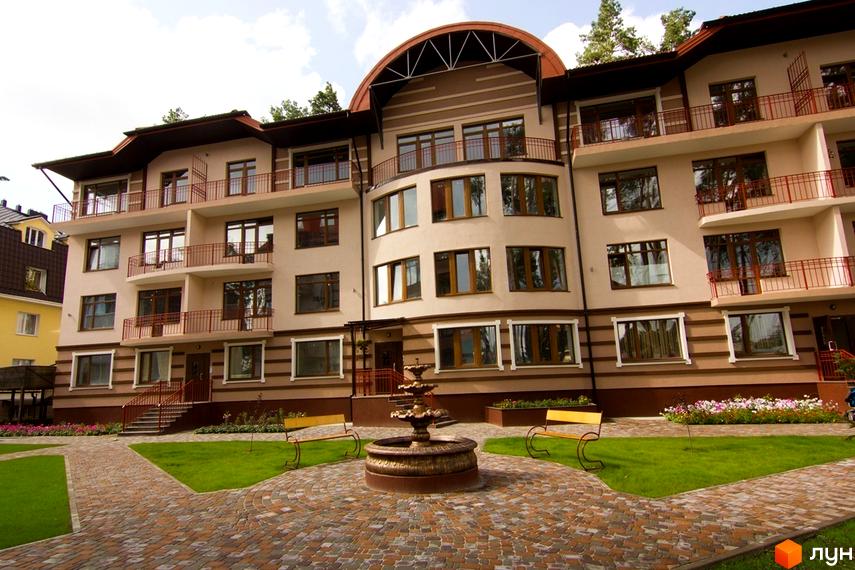 Житловий комплекс Жемчужина города з багатоповерховими будинками та балконами. На прибудинковій території розташовані лавки та фонтан.