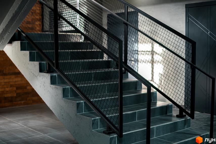 Сучасні сходи з металевим поручнем та сіткою в ЖК Клубне містечко 12. Зовнішній вигляд сходів відповідає загальному стилю комплексу.