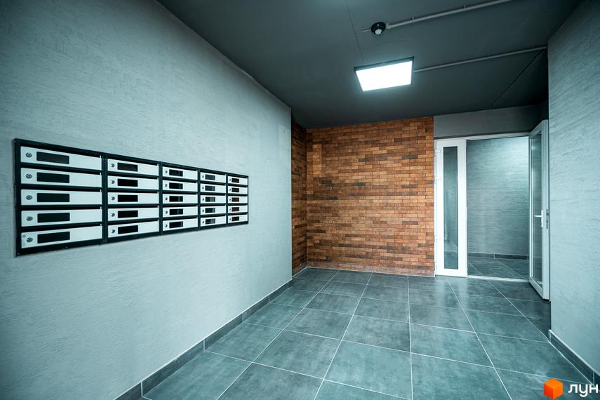 Комплекс Клубне містечко 12. Вхідна група з поштовими скриньками та цегляною стіною.