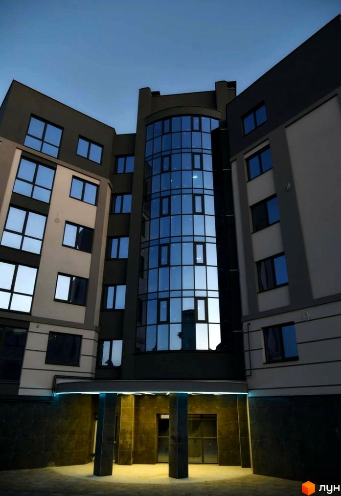 Зовнішній вигляд будинку на вулиці Коперника, 83. Фасад з великими вікнами та скляною вставкою, вхідна зона з освітленням.