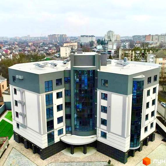 Зображення фасаду житлового комплексу на вулиці Коперника, 83. Багатоповерхова будівля з великими вікнами та благоустроєм навколо.