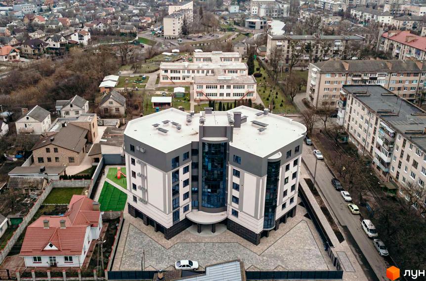 Зображення Житлового комплексу по вулиці Коперника, 83. Багатоповерхова будівля з великими вікнами та облаштованою прибудинковою територією.