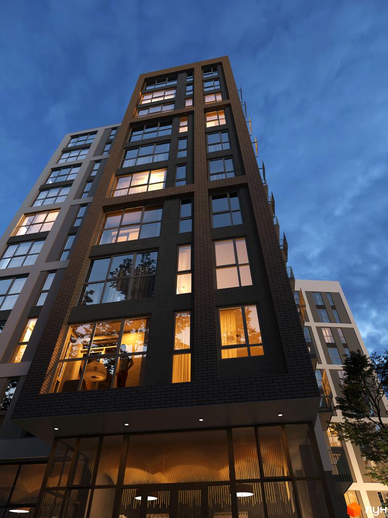 Сучасний житловий комплекс SYMBOL з цегляним фасадом та великими вікнами. Зовнішній вигляд новобудови ввечері.