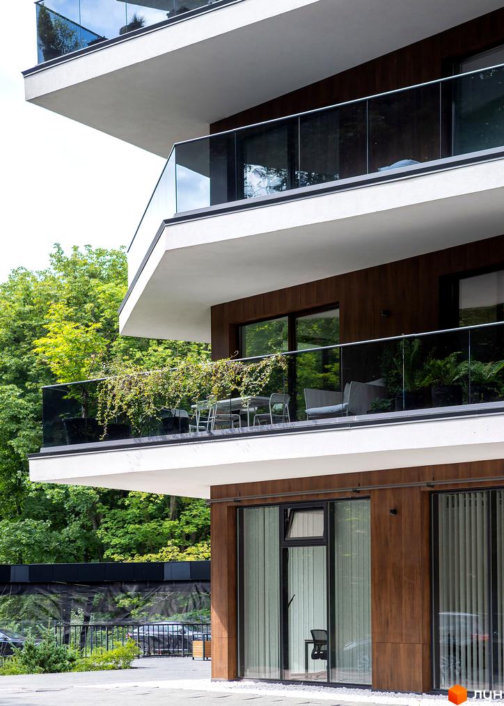 Житловий комплекс Avalon Lux з сучасними балконами та скляними огорожами. Навколо багато зелені та дерев, що створює приємну атмосферу.