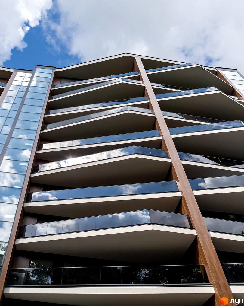 Зовнішній вигляд житлового комплексу Avalon Lux з виступаючими балконами та скляними фасадами. Архітектура будівлі підкреслюється дерев'яними елементами та скляними перилами.