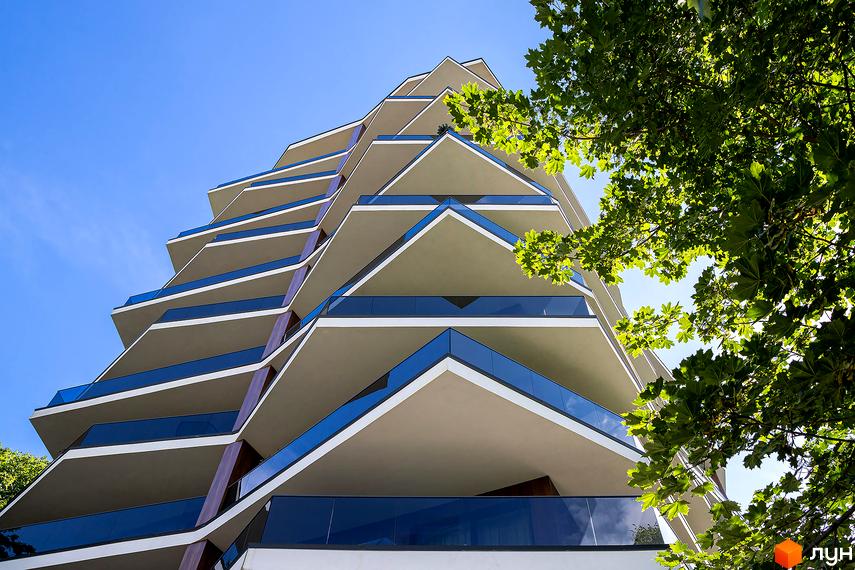 Житловий комплекс Avalon Lux з унікальною архітектурою та балконами. Зовнішній вигляд новобудови з скляними огорожами та виступаючими елементами.