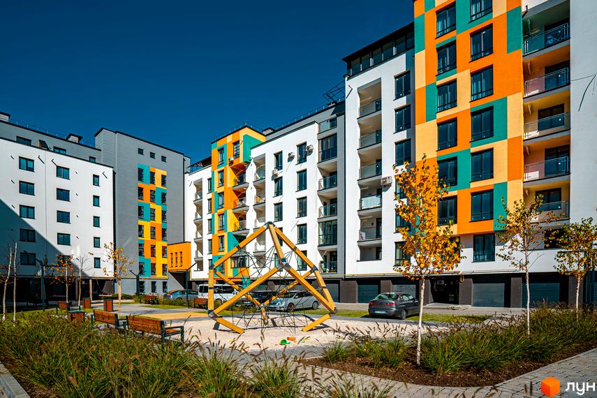 Житловий комплекс Квартал Краківський з яскравим фасадом та дитячим майданчиком. Сучасна архітектура та облаштована прибудинкова територія.