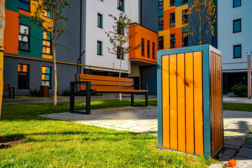 Житловий комплекс Квартал Краківський. Сучасна архітектура будівель з яскравими фасадами та облаштована прибудинкова територія з лавкою та урною.