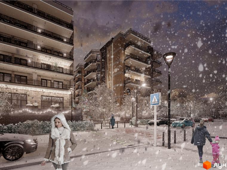 Житловий комплекс CENTRAL PARK у зимовий вечір зі снігом, з фасадами будівель, що світяться, та людьми на вулиці.