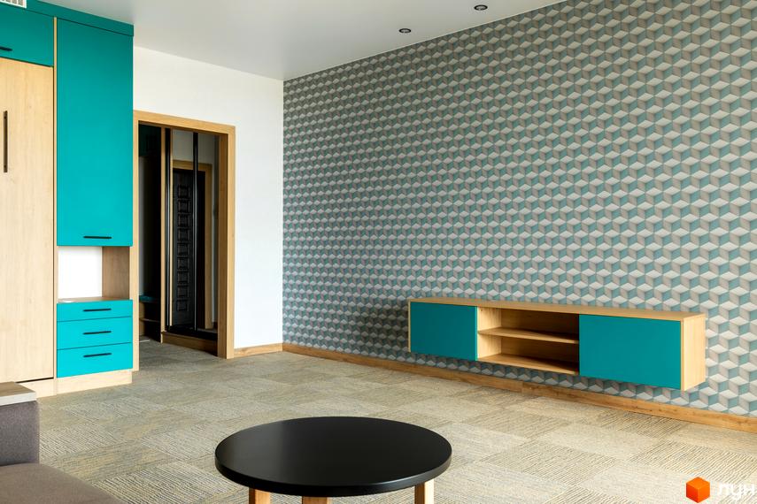 Інтер'єр кімнати в Житловому комплексі Арден Курортний з меблями в бірюзових тонах та круглим столиком.