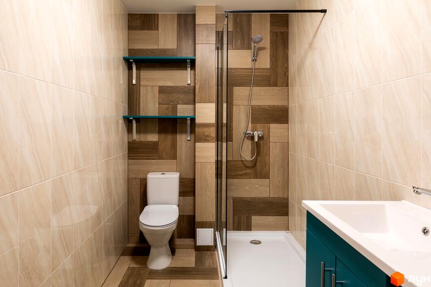 Сучасний дизайн ванної кімнати з туалетом, душовою кабіною та раковиною. Оздоблення стін плиткою під дерево та світлою плиткою.