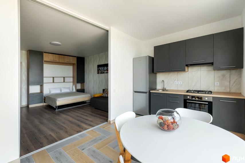 Інтер'єр квартири в Житловому комплексі Арден Курортний: кухня, обідній стіл і вид на кімнату з ліжком. Затишний простір для життя.