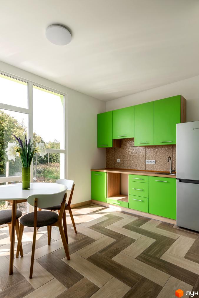Інтер'єр кухні в ЖК Арден Курортний з яскравими зеленими фасадами та обідньою зоною біля великого вікна з видом на зелень.
