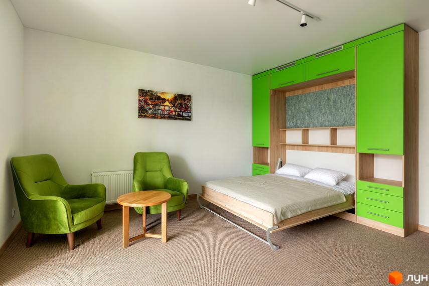 Сучасна спальня з двома зеленими кріслами та круглим столиком у ЖК Арден Курортний. Ліжко з білою спинкою та зеленою шафою.