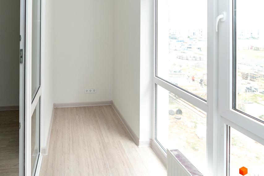 Інтер'єр квартири в житловому комплексі ARTVILLE з великим вікном та видом на міську забудову. Сучасний ремонт та функціональне планування.