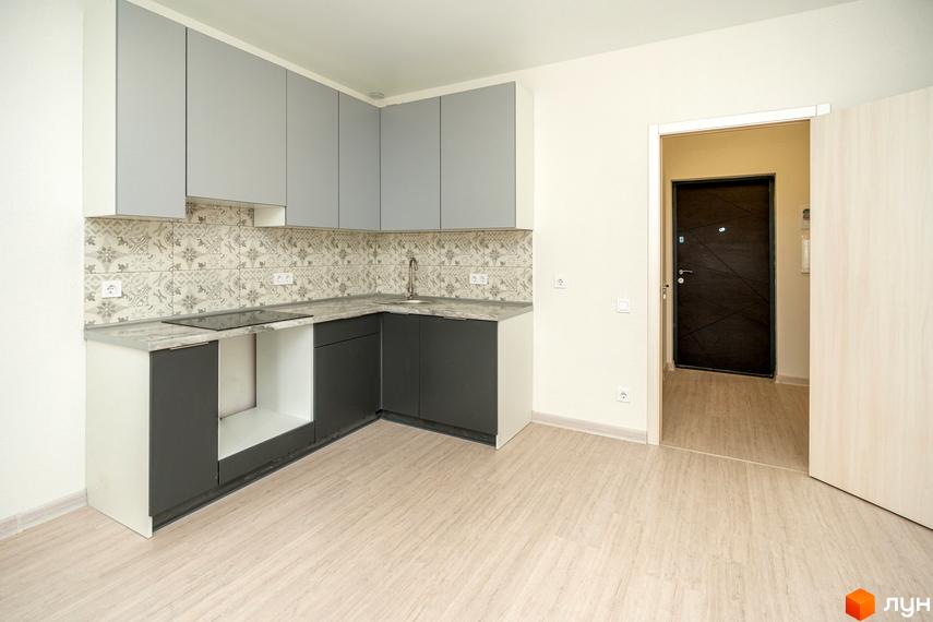 Кухня в новобудові Житлове містечко ARTVILLE з кутовим гарнітуром сірого кольору, світлою стільницею та візерунковим фартухом. На підлозі світлий ламінат.