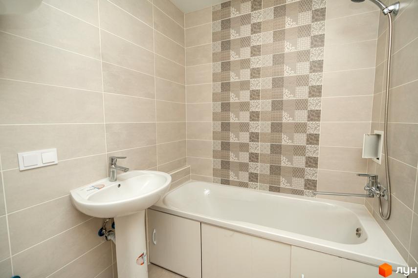 Ванна кімната в Житловому містечку ARTVILLE з бежевою плиткою, декоративною стіною та білою сантехнікою.