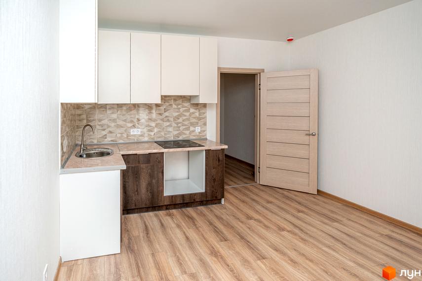 Житловий комплекс ARTVILLE: фото кухні з білими шафами, дерев'яною стільницею, плитою та дверима в сусідню кімнату.