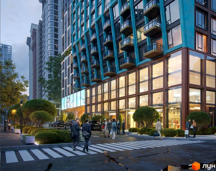 Зовнішній вигляд новобудови з бірюзовими фасадами та скляним першим поверхом, з пішохідним переходом та зеленими зонами перед фасадом.