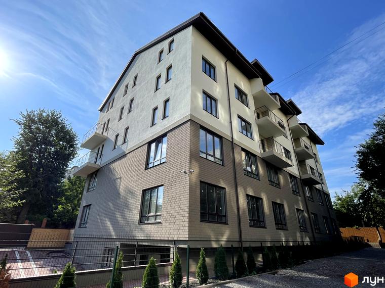 Багатоповерховий будинок Клубний будинок Barkey з фасадом у світлих тонах та балконами. Територія облаштована зеленими насадженнями та парканом.
