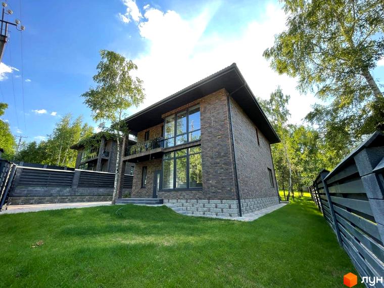 Котеджне містечко Elegant House: двоповерховий будинок з темно-цегляним фасадом, великими вікнами та балконом. Навколо будинку зелений газон та дерева.