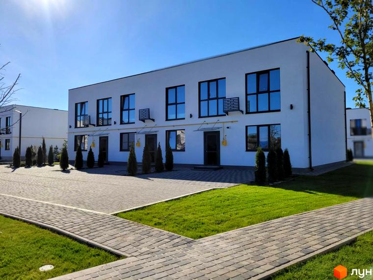 Таунхауси DREAM HOUSE – двоповерхові будинки з великими вікнами та кондиціонерами, розташовані на доглянутій території з бруківкою та газоном.