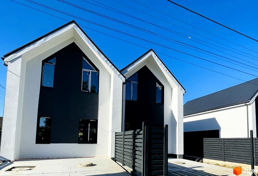 Дуплекси „На Зоряному“: двоповерхові будинки з чорно-білими фасадами та великими вікнами, огороджені темним парканом.